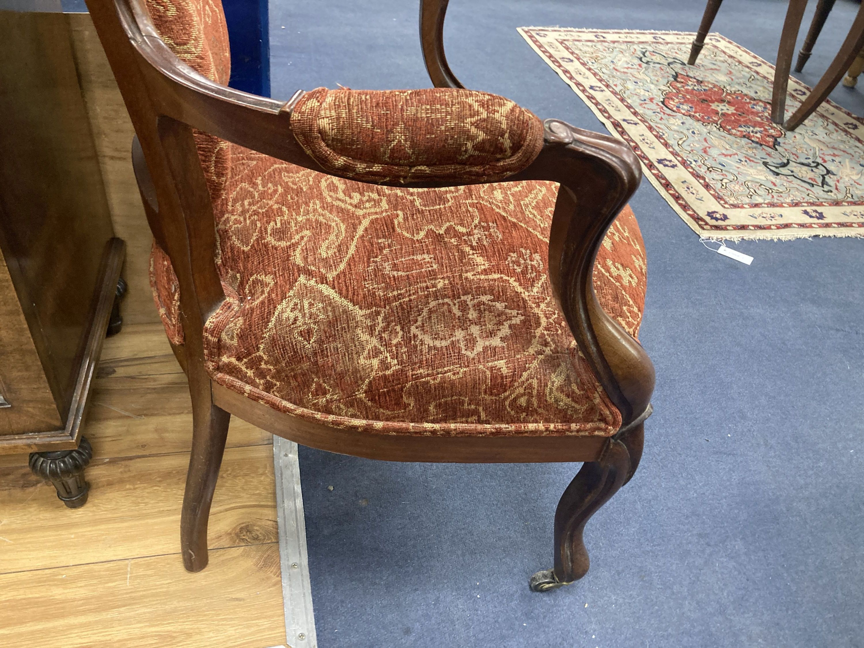 A Victorian mahogany upholstered spoon back upholstered elbow chair, 95cm high, width 63cm
